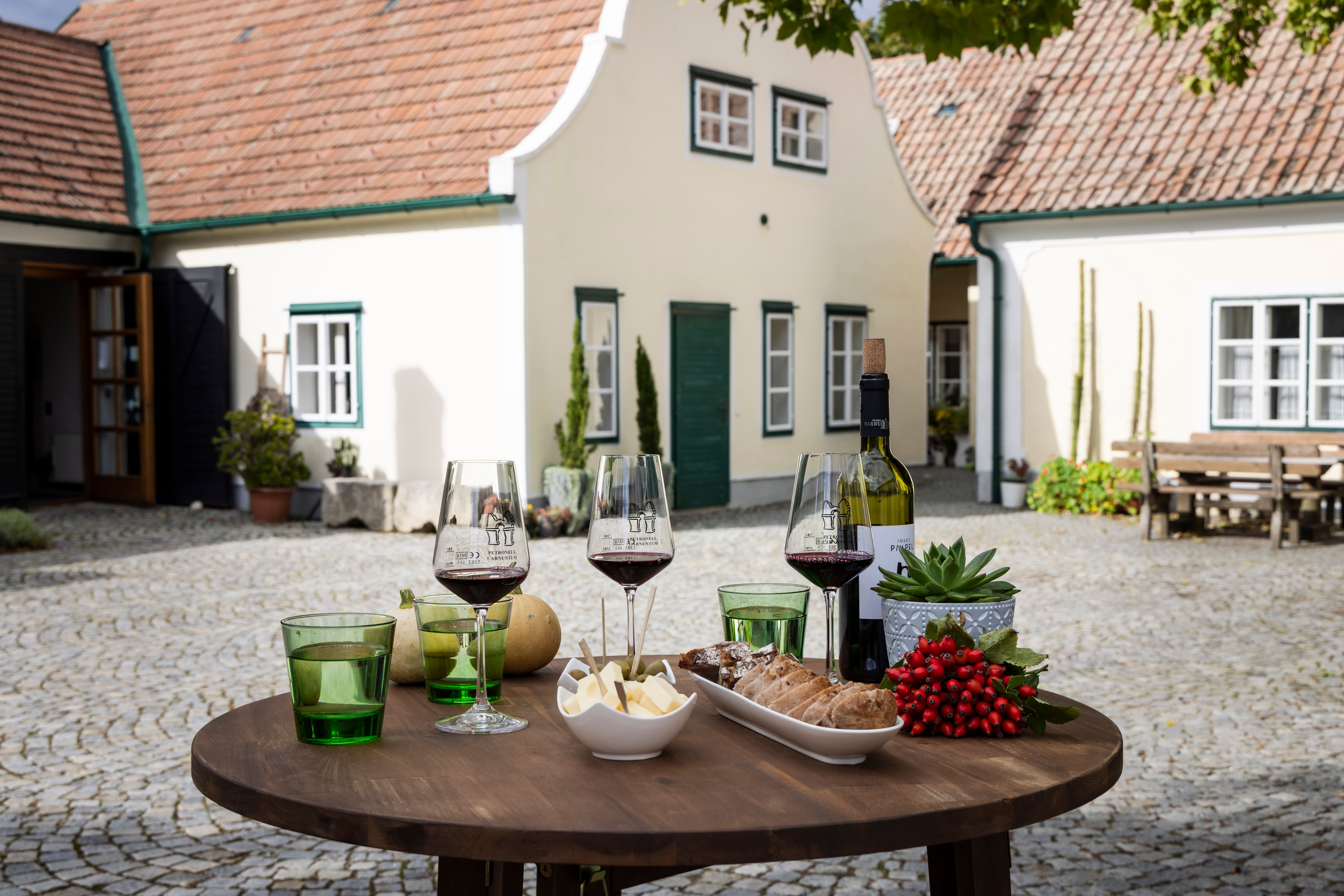 Table with wine glasses, cheese and bread at the winery in the courtyard