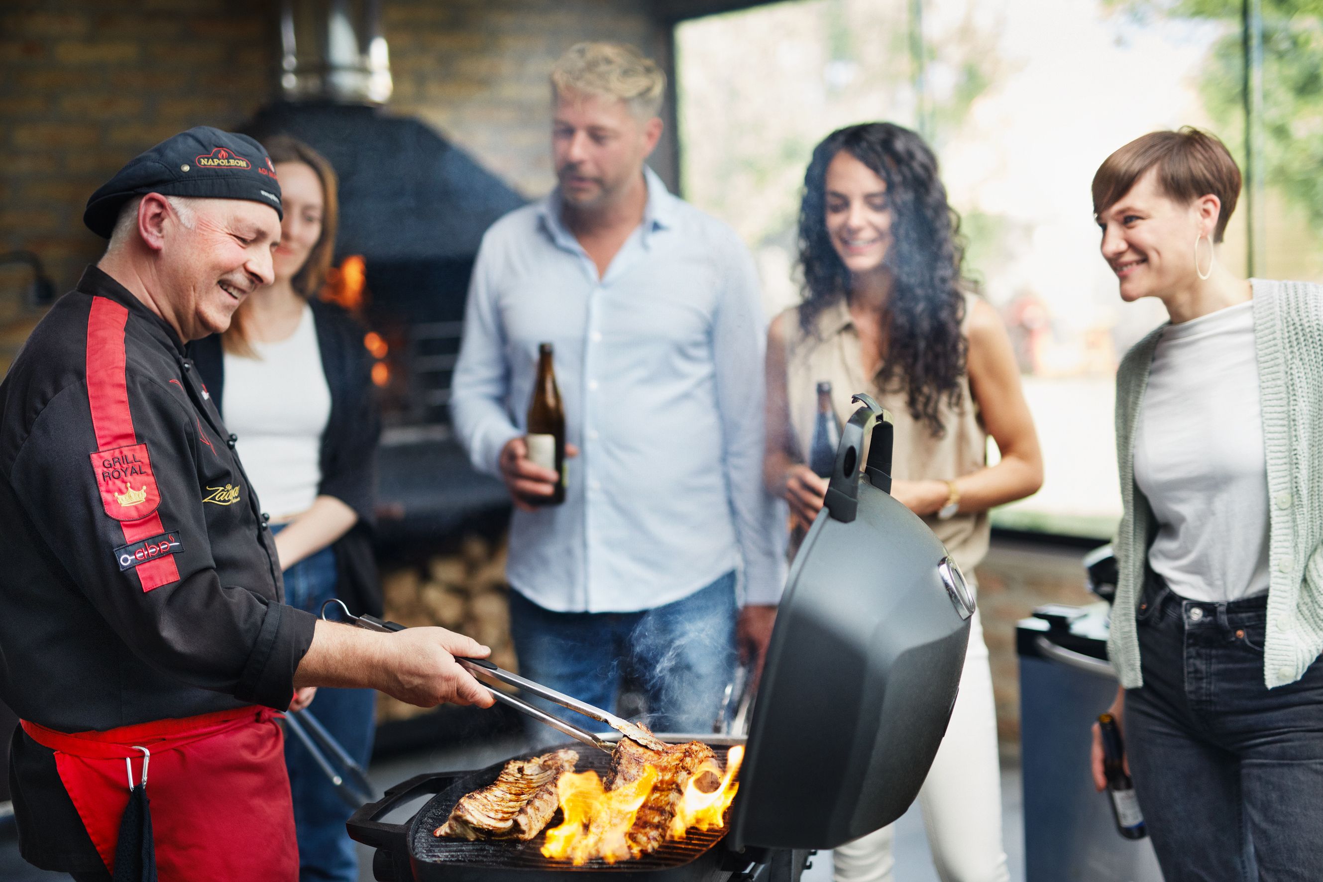 A barbecue master shows a group of people how to prepare meat on a barbecue. 