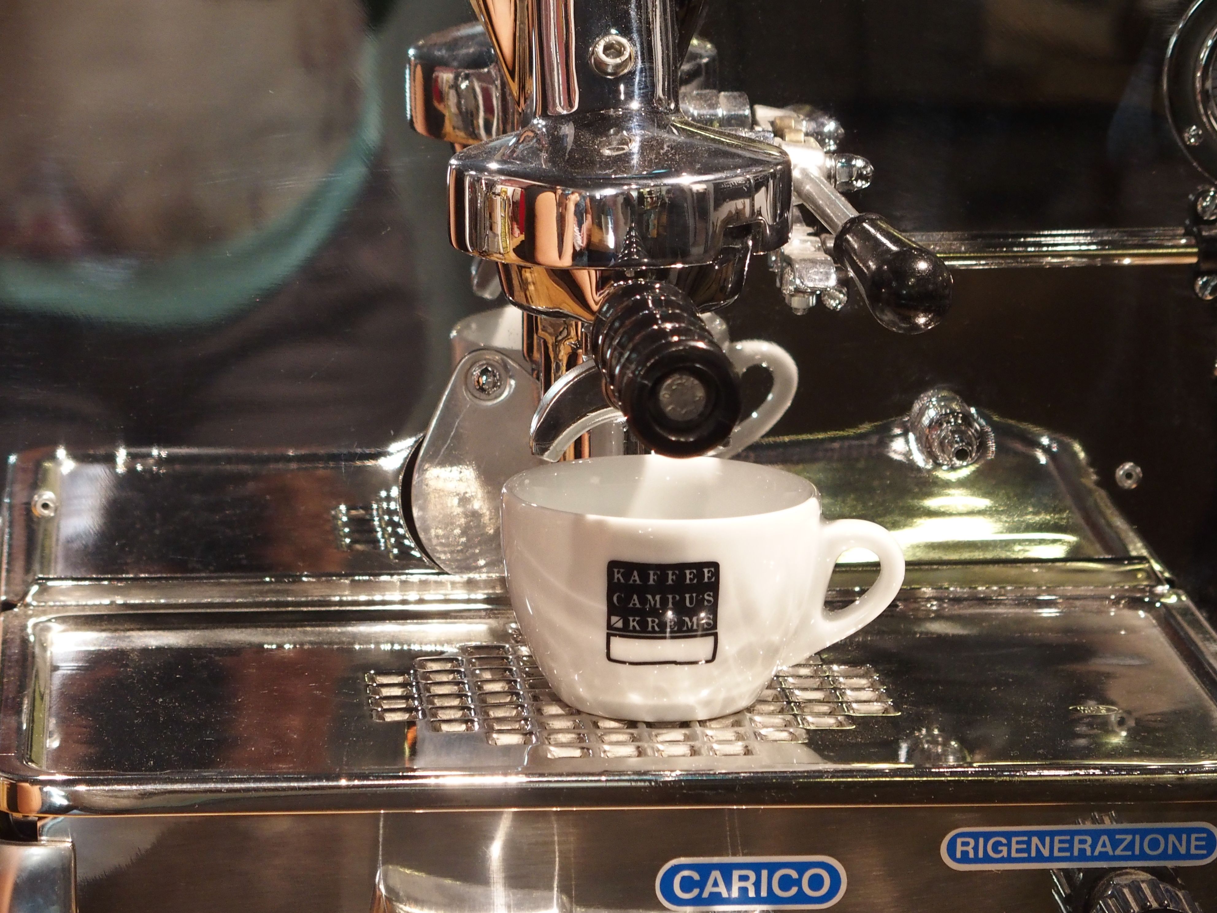 Espresso machine with cup that brews coffee.