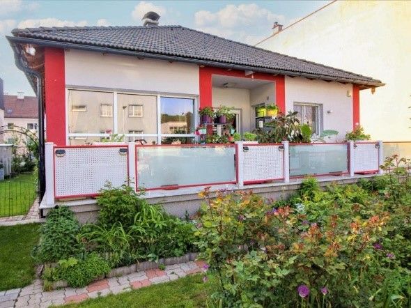 gray red house with balcony and flowers 
