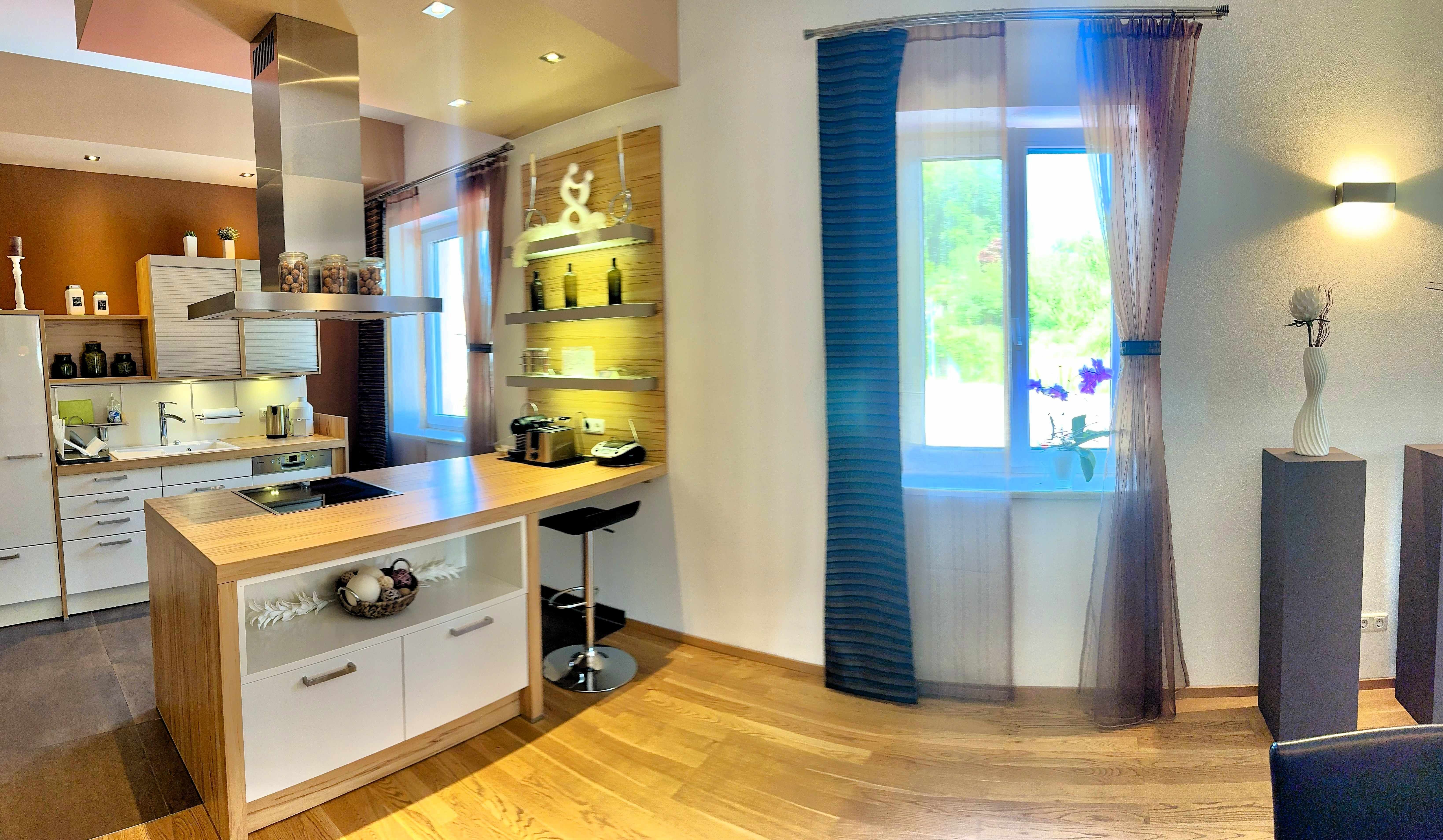 Modern kitchen with a wooden countertop and white cabinets.