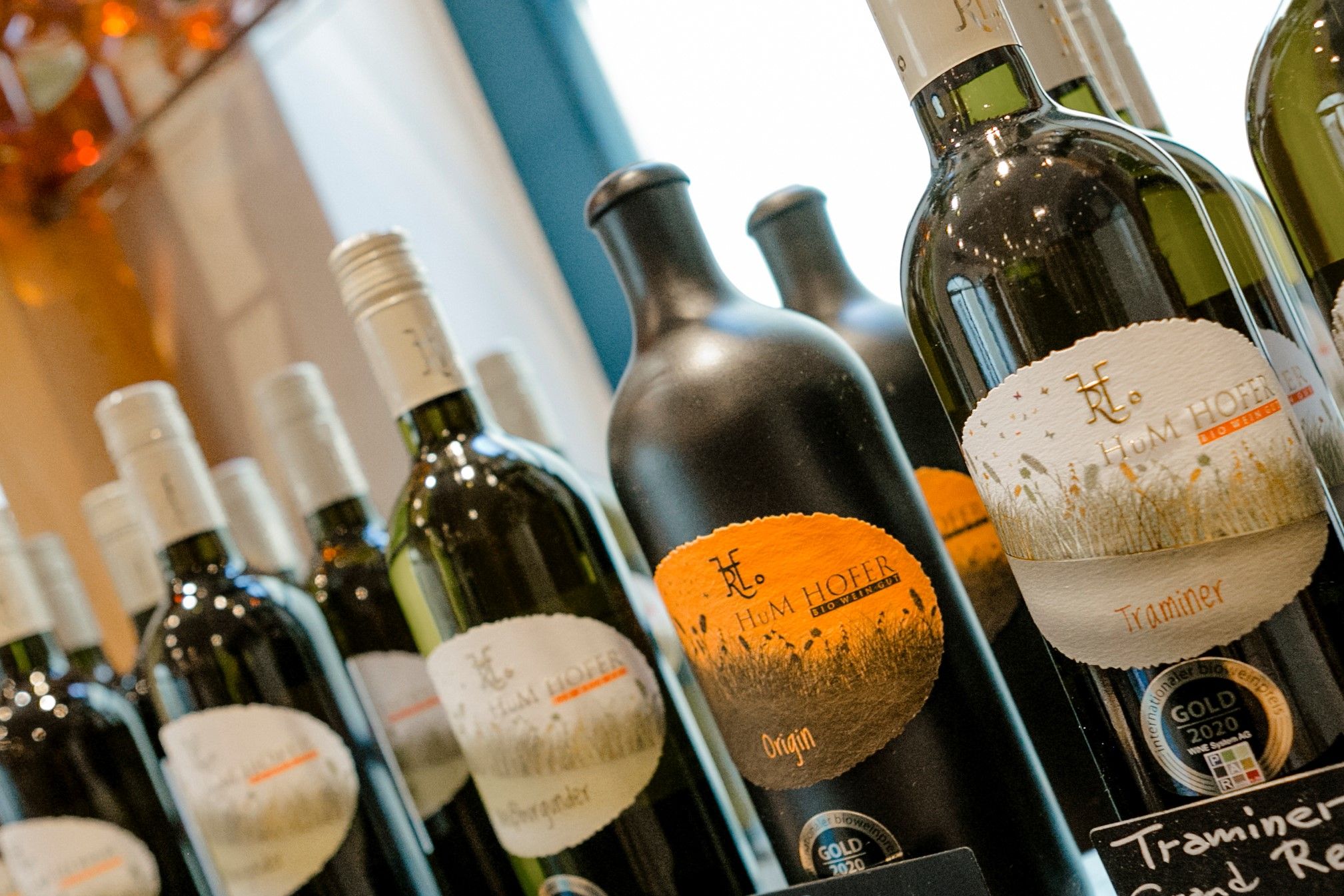 Close-up of wine bottles with Hum Hofer brand labels.