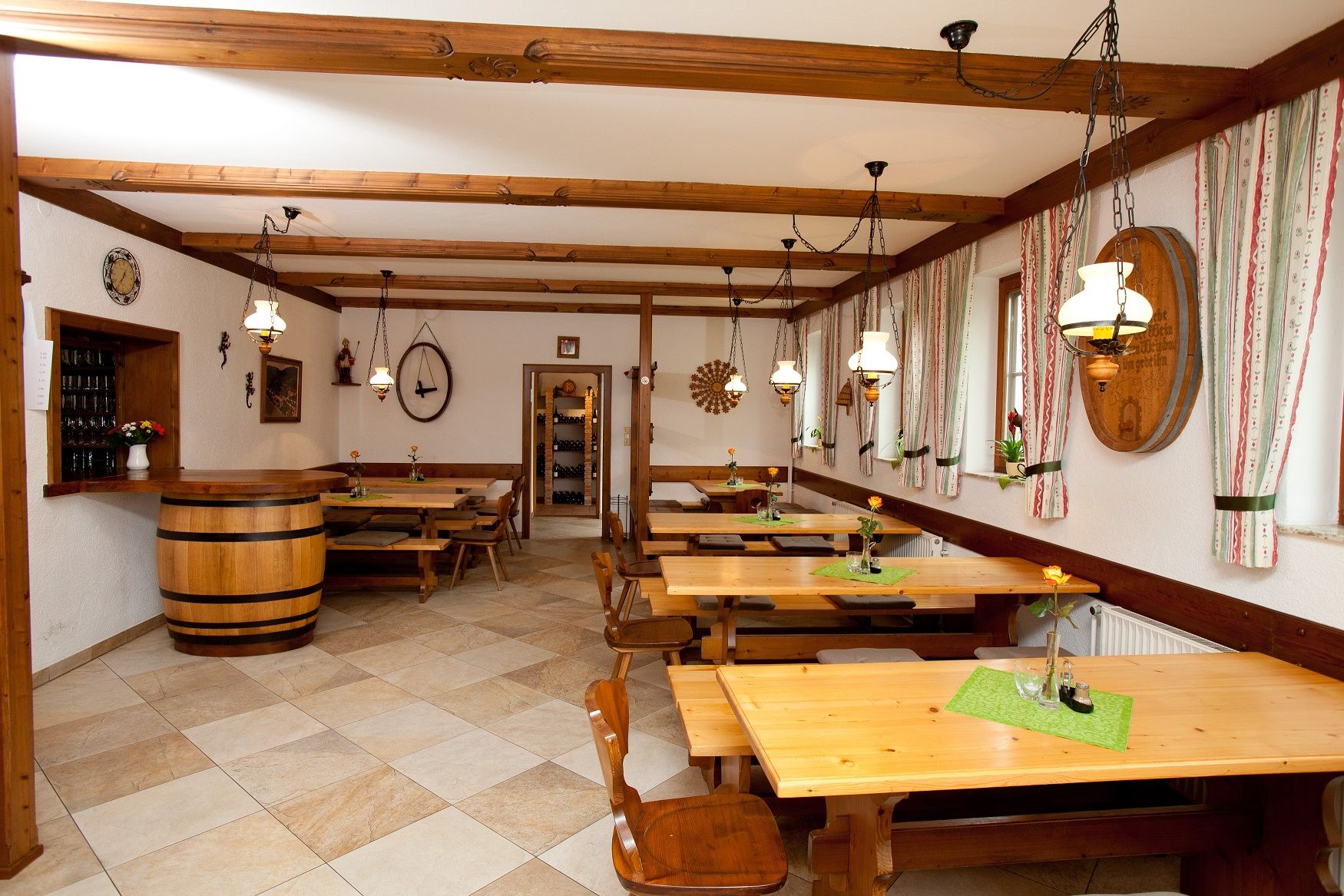 Interior view of a wine tavern with wooden tables, chairs and rustic decoration.