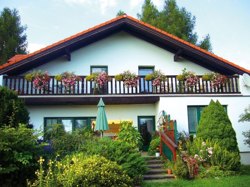 A two-story house with a balcony and flowers.