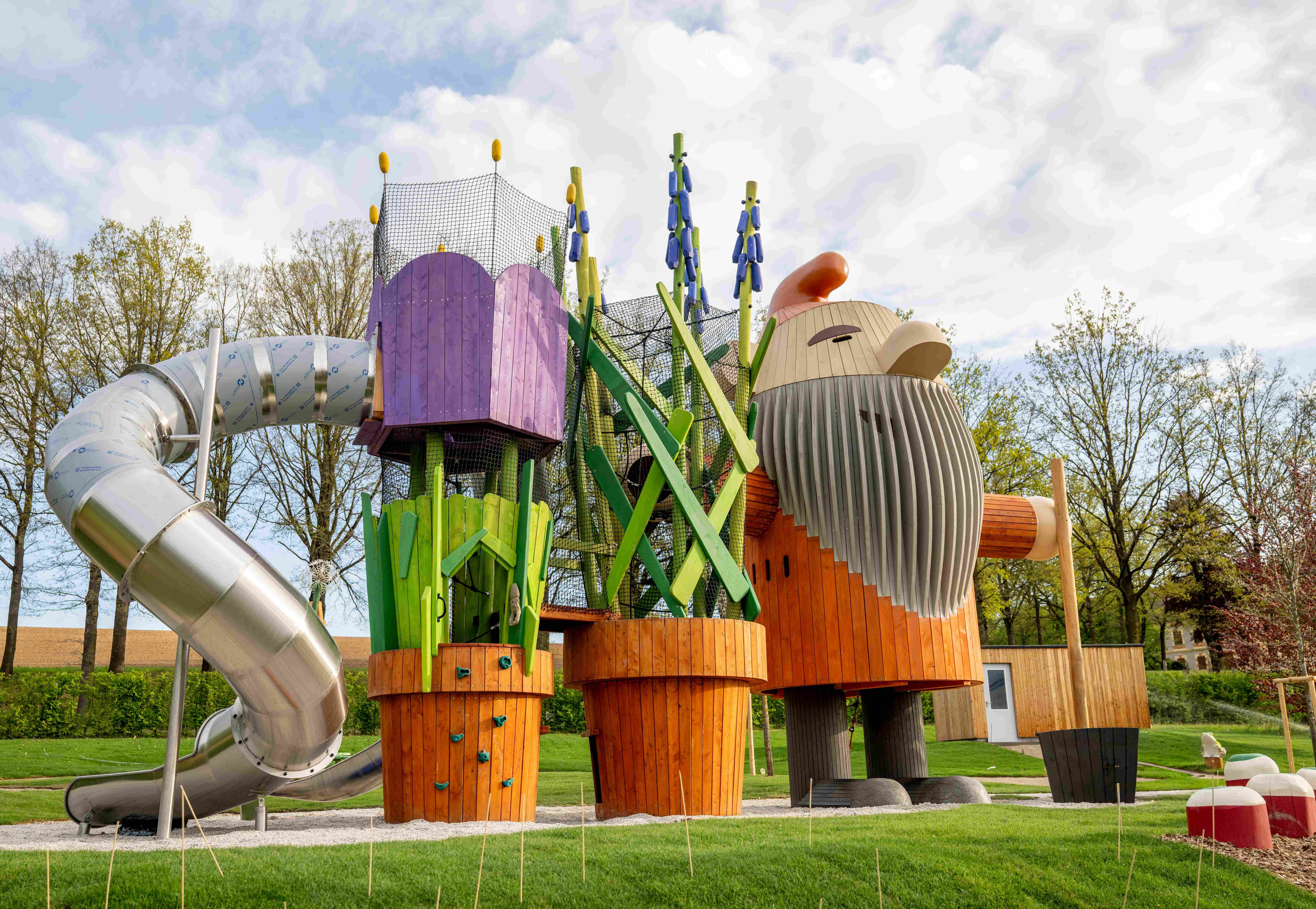 An imaginative playground with a large wooden figure and a slide.