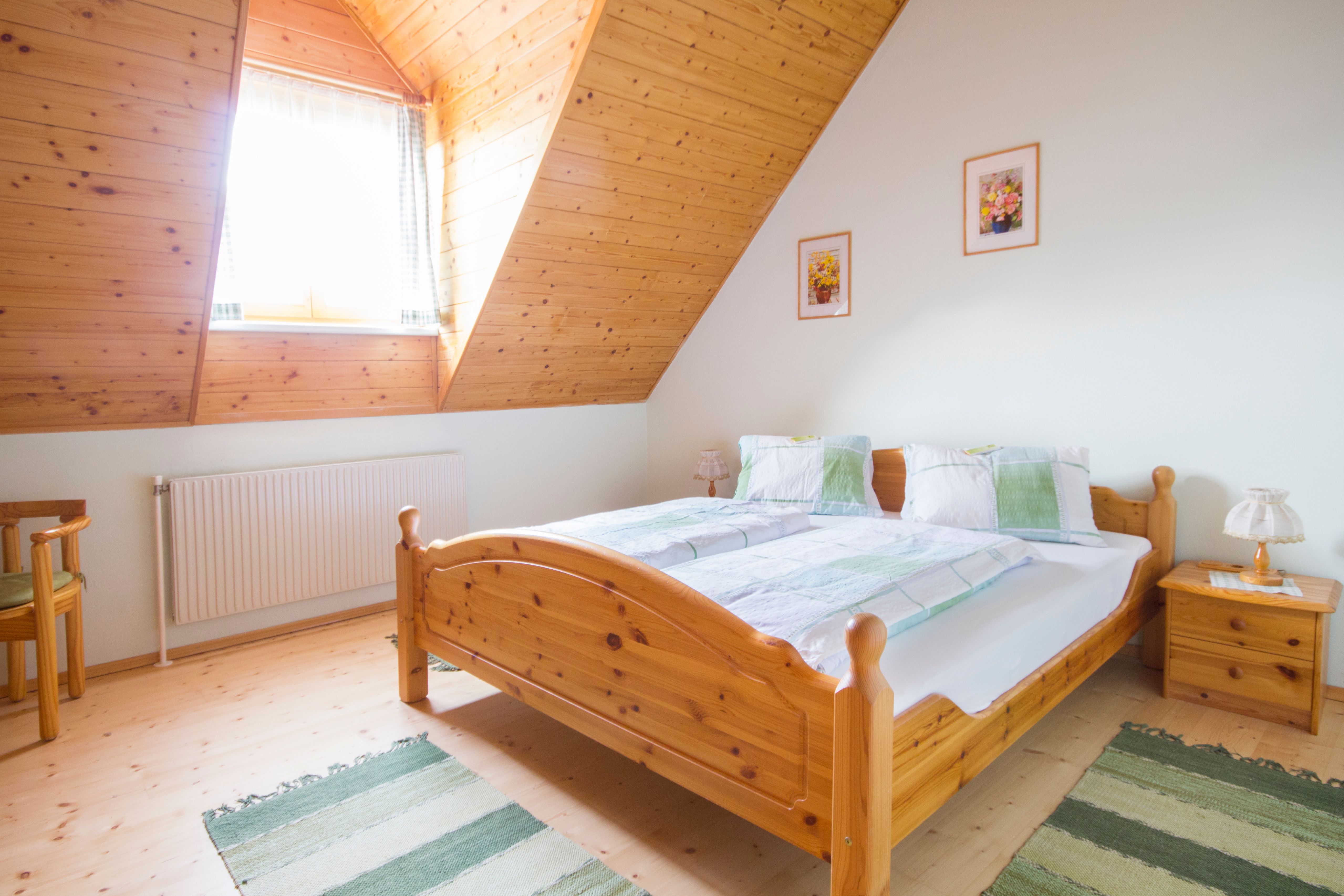 Cozy bedroom with wooden furniture and sloping ceiling.
