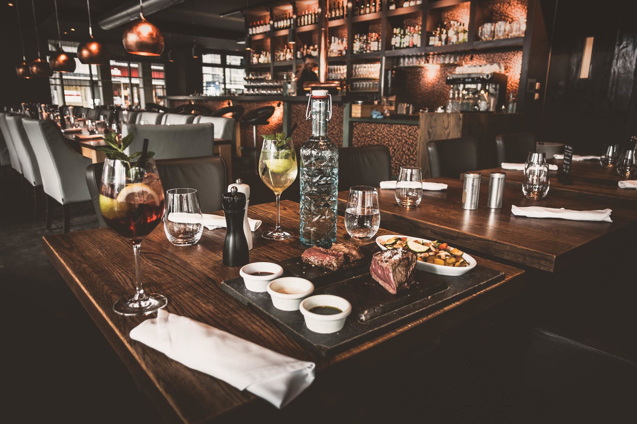 Elegant restaurant with table setting, drinks and food.