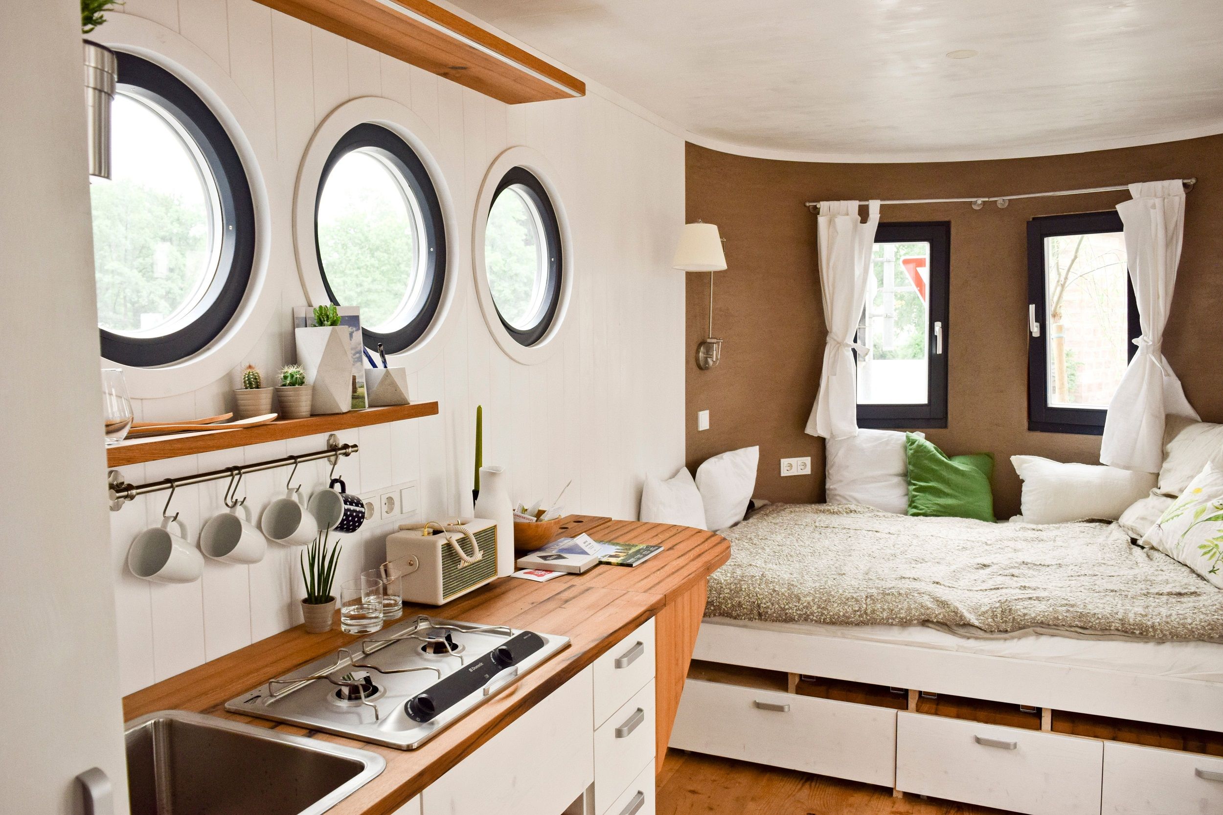 Interior view of a caravan with kitchen and bed.