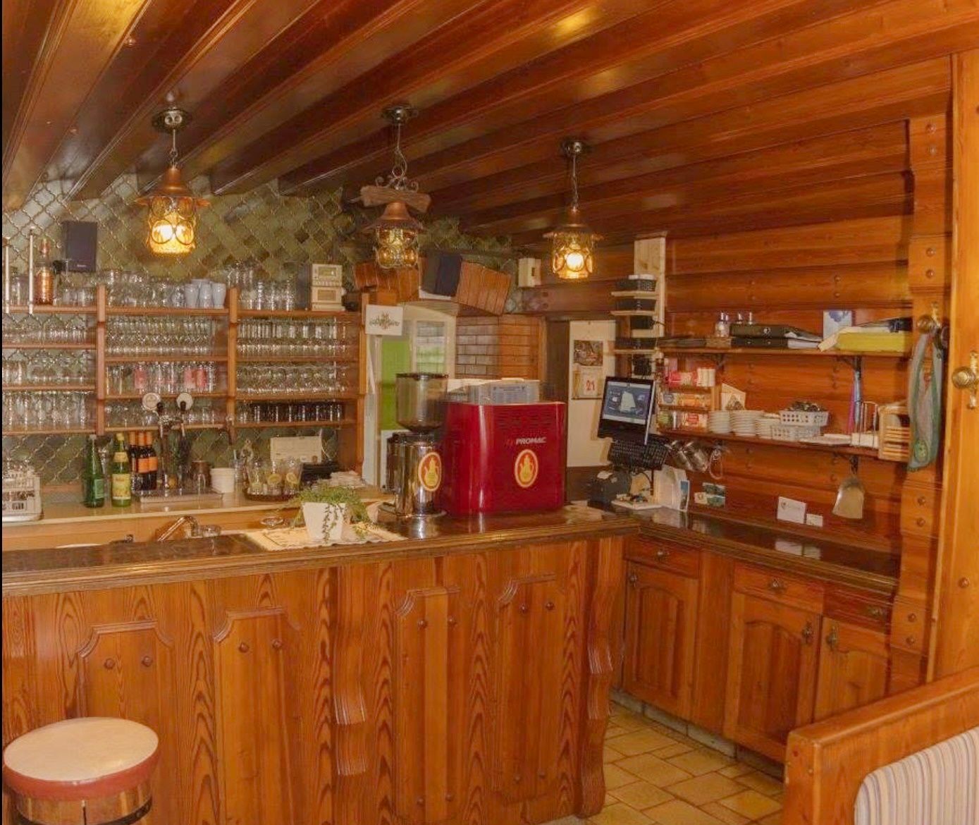 Rustic bar area with wooden furniture and glasses.