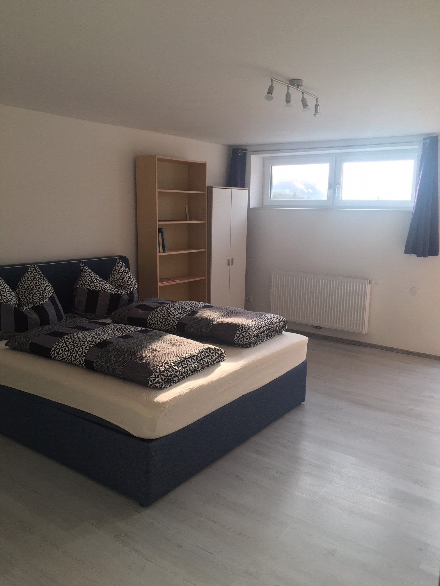 Bedroom with double bed, wooden floor and window 