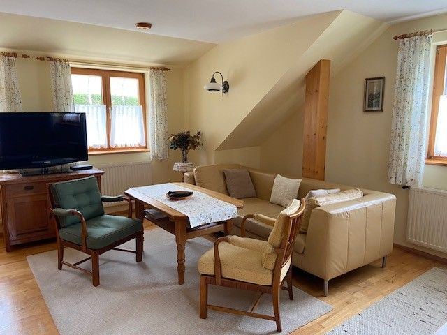 Cozy living room with sofa, armchairs and TV.