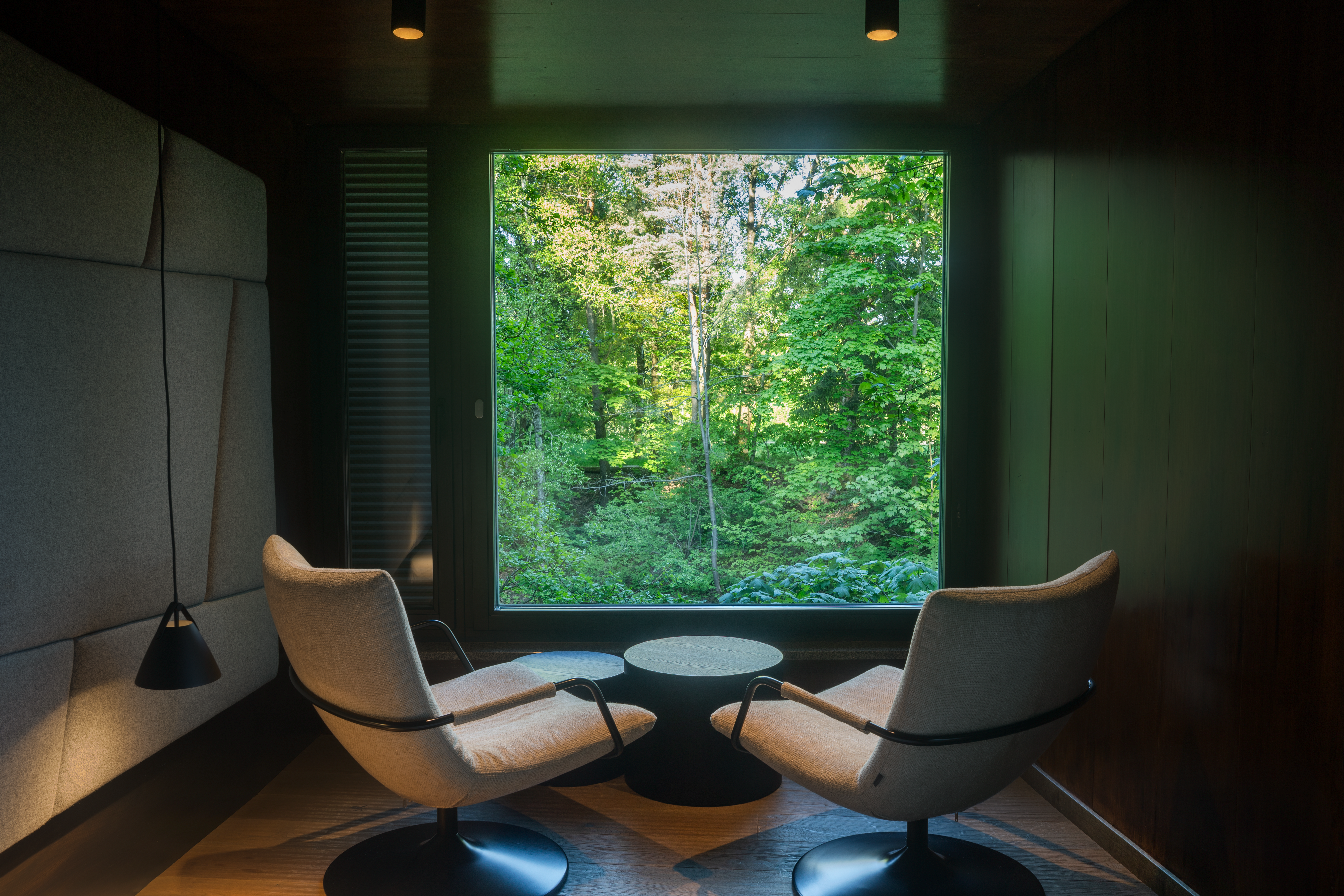 Modern tree house in the forest with balcony and glass front.