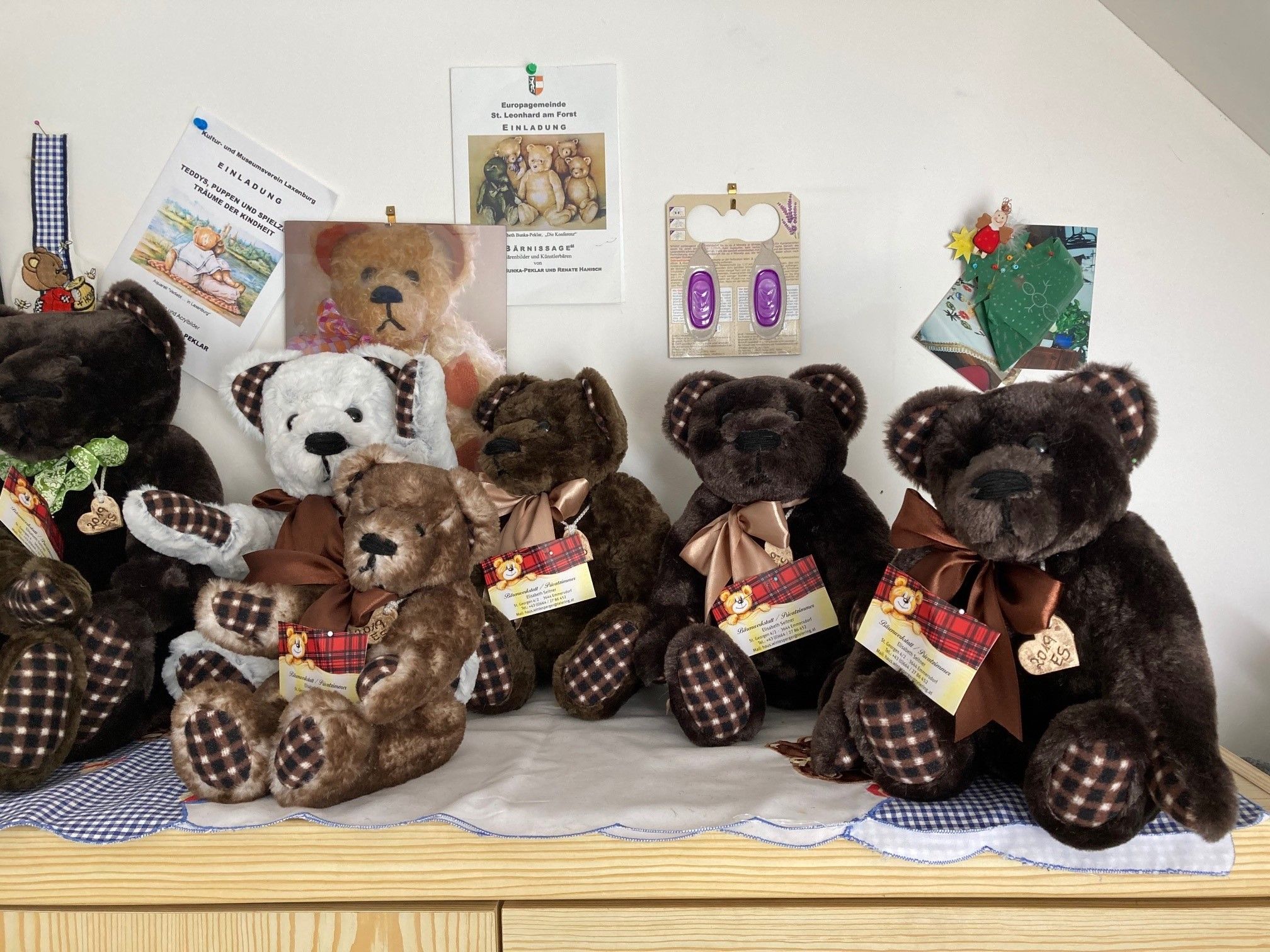 A collection of plush bears with checkered bows on a table.