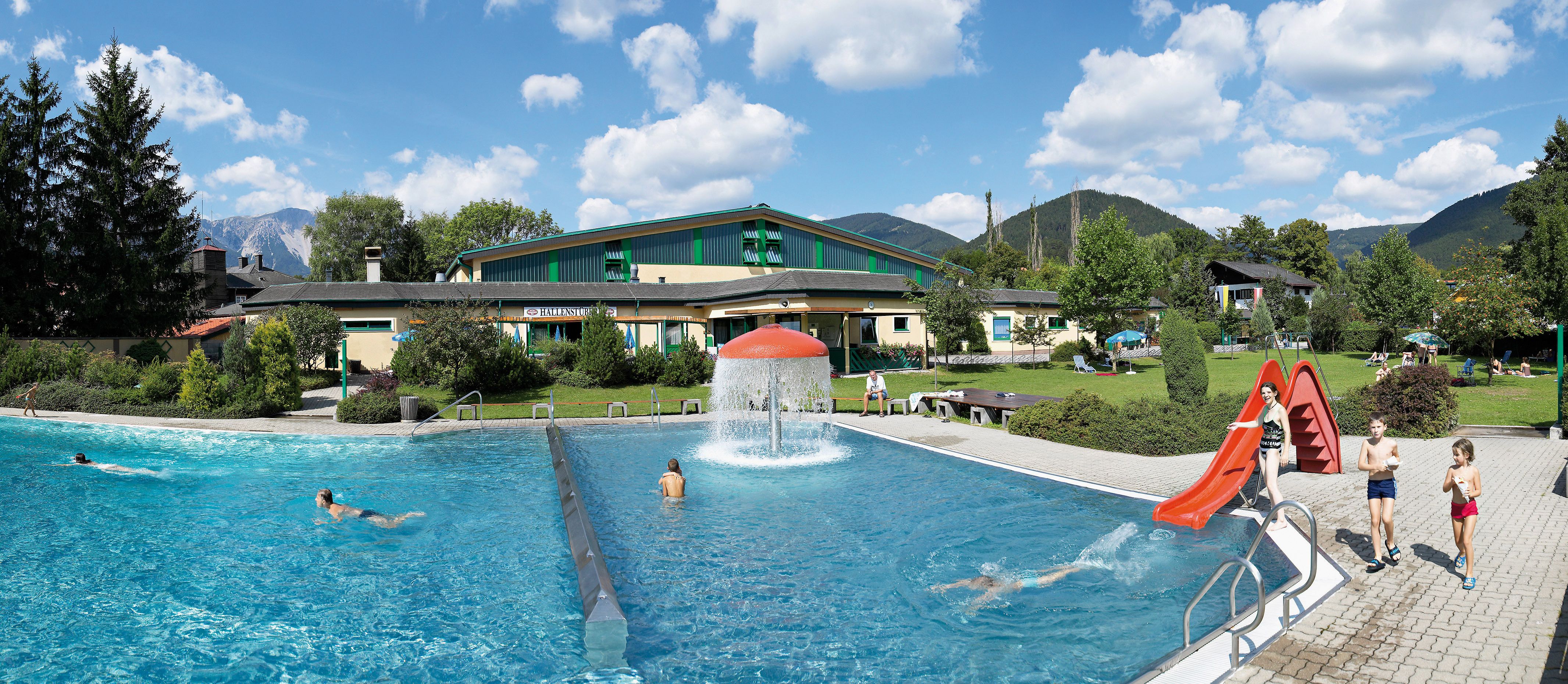 Puchberg outdoor pool with swimming pool, slide and green surroundings.