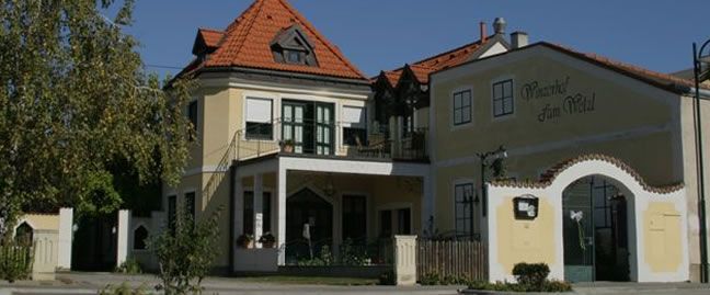A traditional building with a yellow façade and red tiled roof, labeled 'Winzerhof zum Wald'.