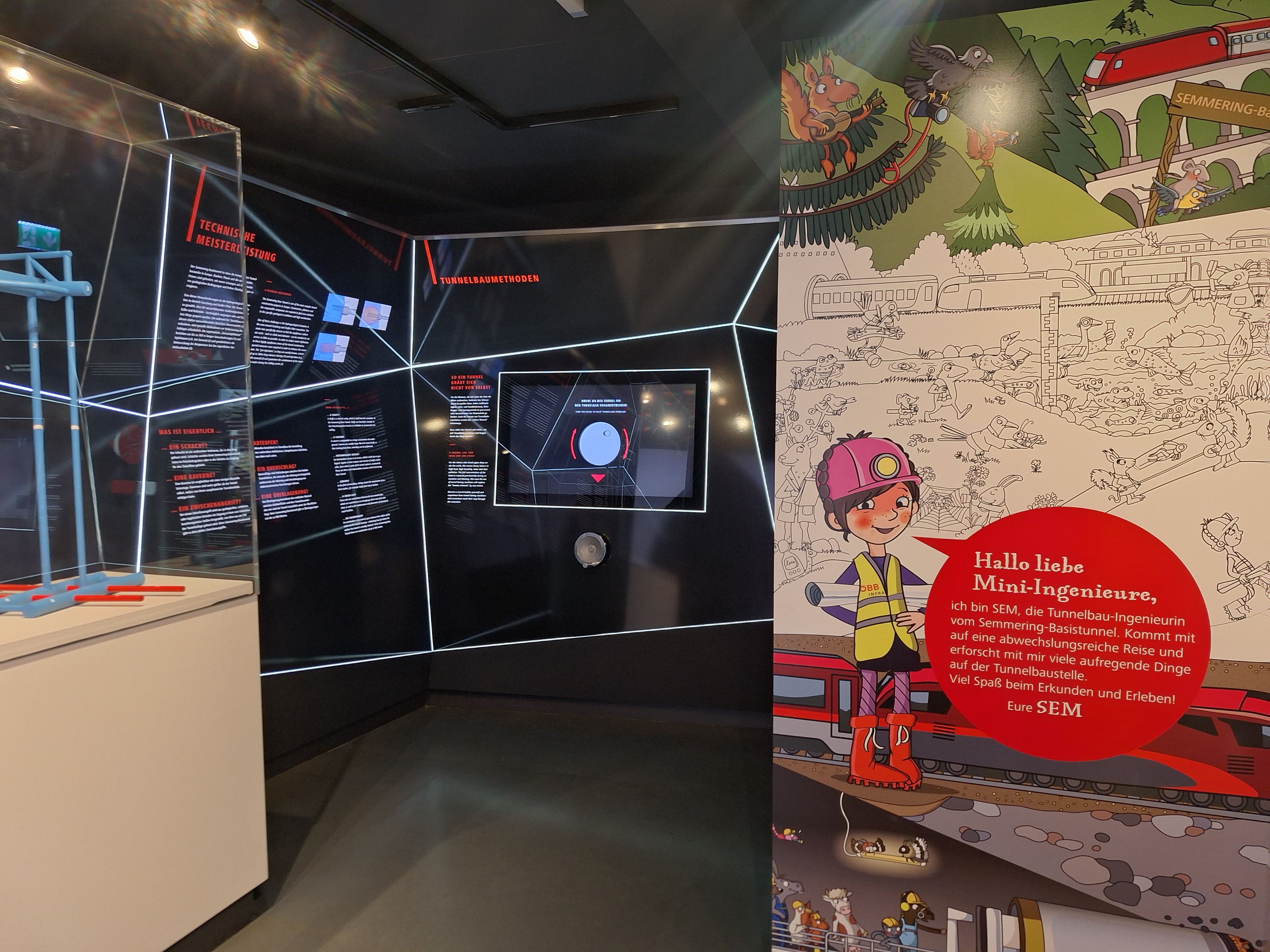 Exhibition about the Semmering Base Tunnel with information boards and children's illustrations.