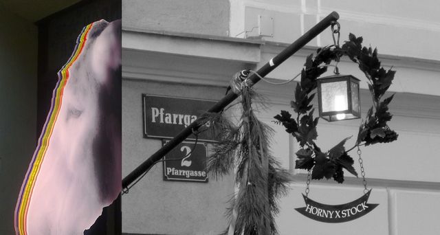 A donkey's head with colorful stripes next to a street sign and a lantern with a wreath.