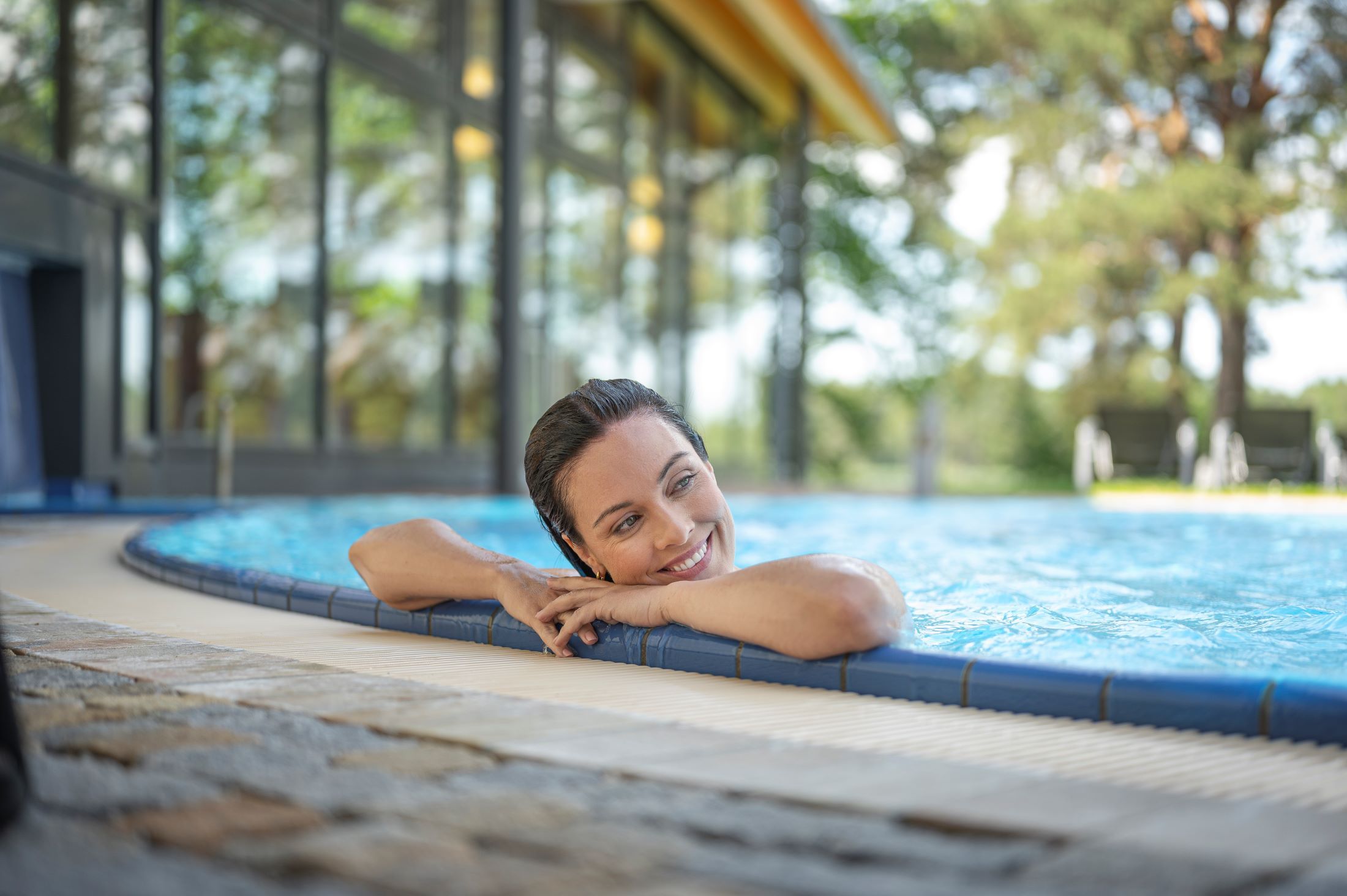 Woman relaxing in the pool at the edge.
