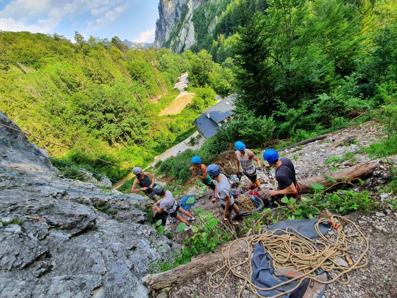 Group of climbers with helmets on a rock in the forest.