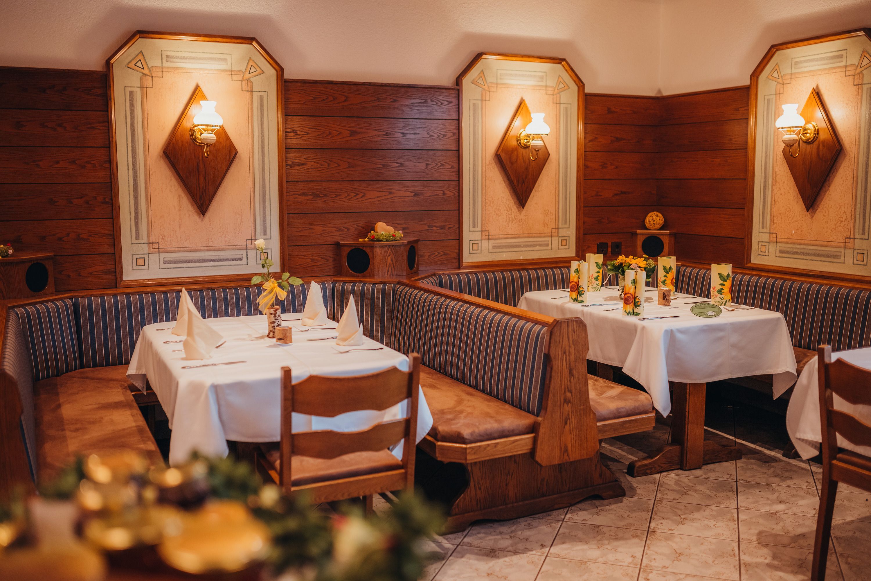 Cozy restaurant with wooden walls and decorated tables.