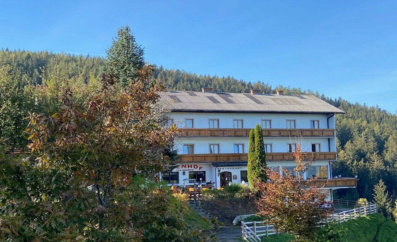 Gasthof-Pension Ödenhof in front of a wooded hill.