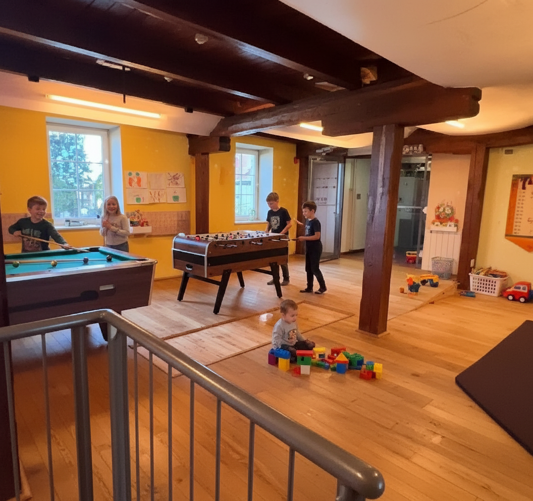 Children play in a playroom with a pool table, table soccer and building blocks.