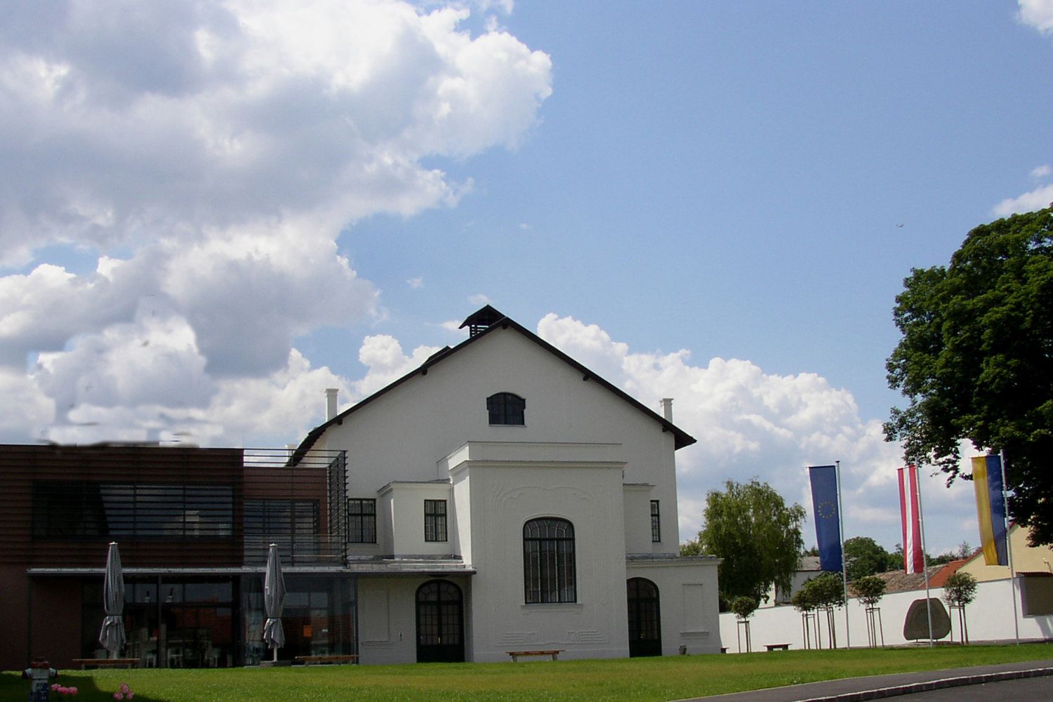 Concert hall Ziersdorf with modern extension and flags in the foreground.