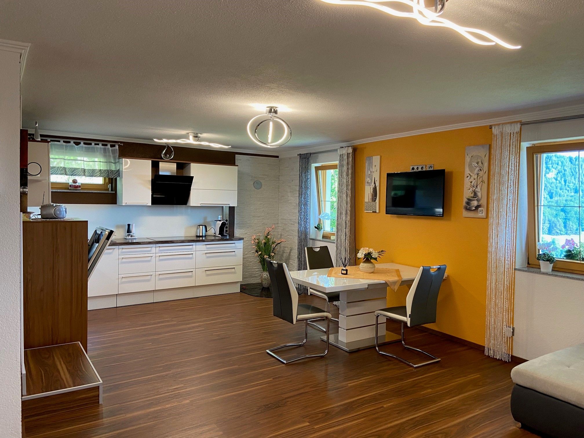 Modern eat-in kitchen with dining table, chairs and fitted kitchen.