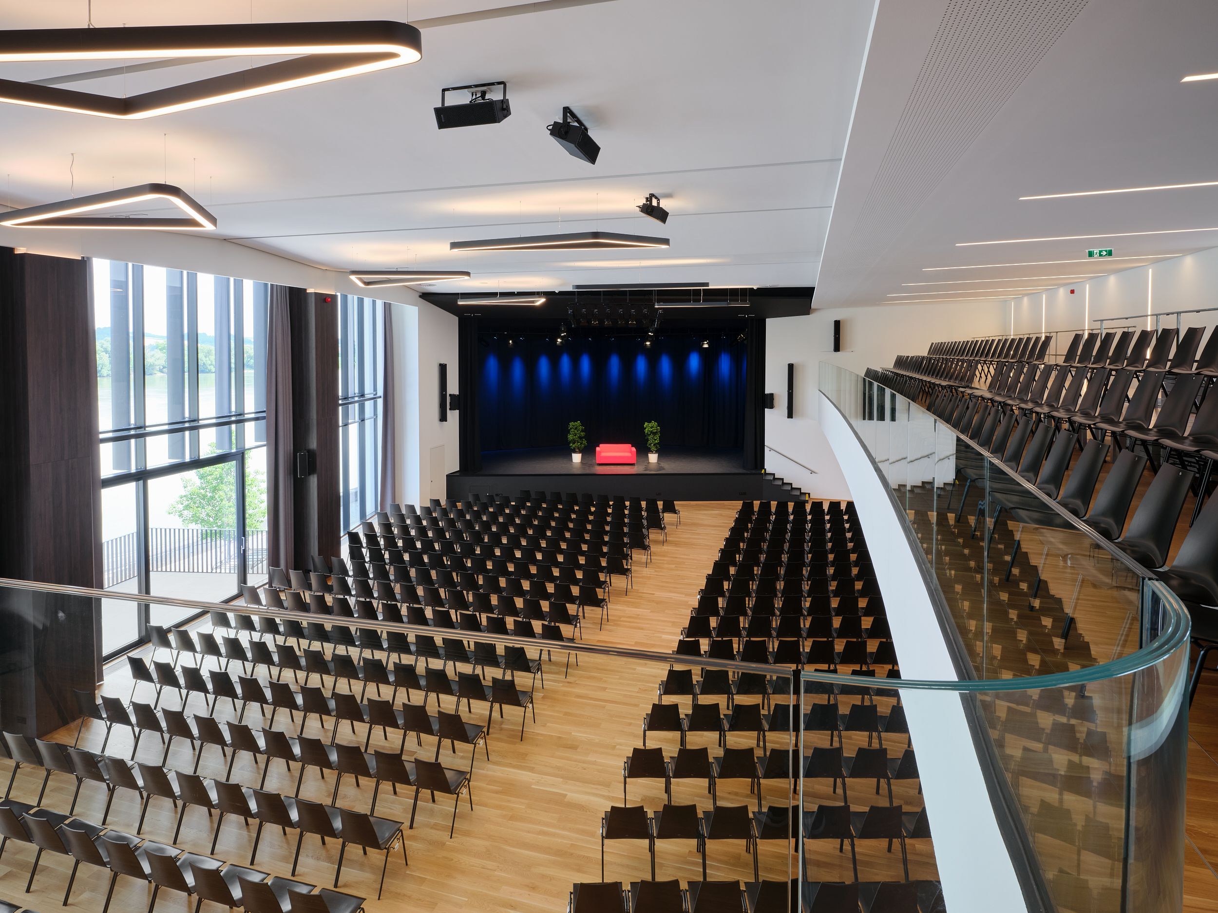 Interior view of Stadthalle Ybbs with empty rows of seats and stage.