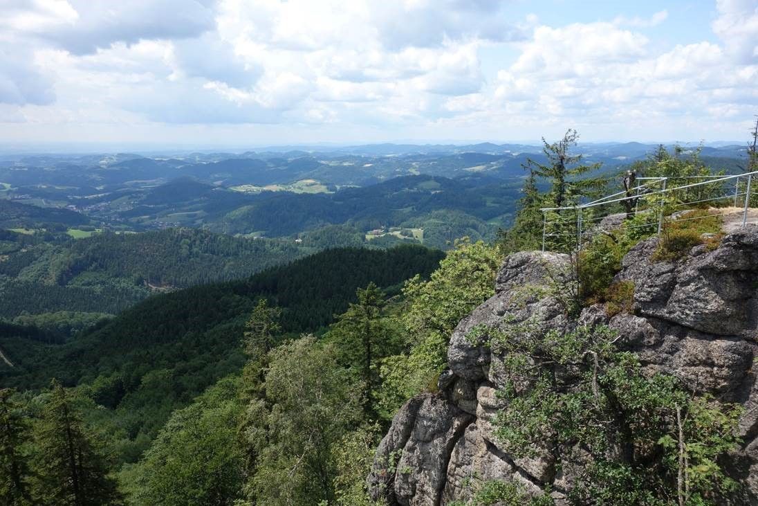 View from the castle stone wall over wooded hills and valleys.