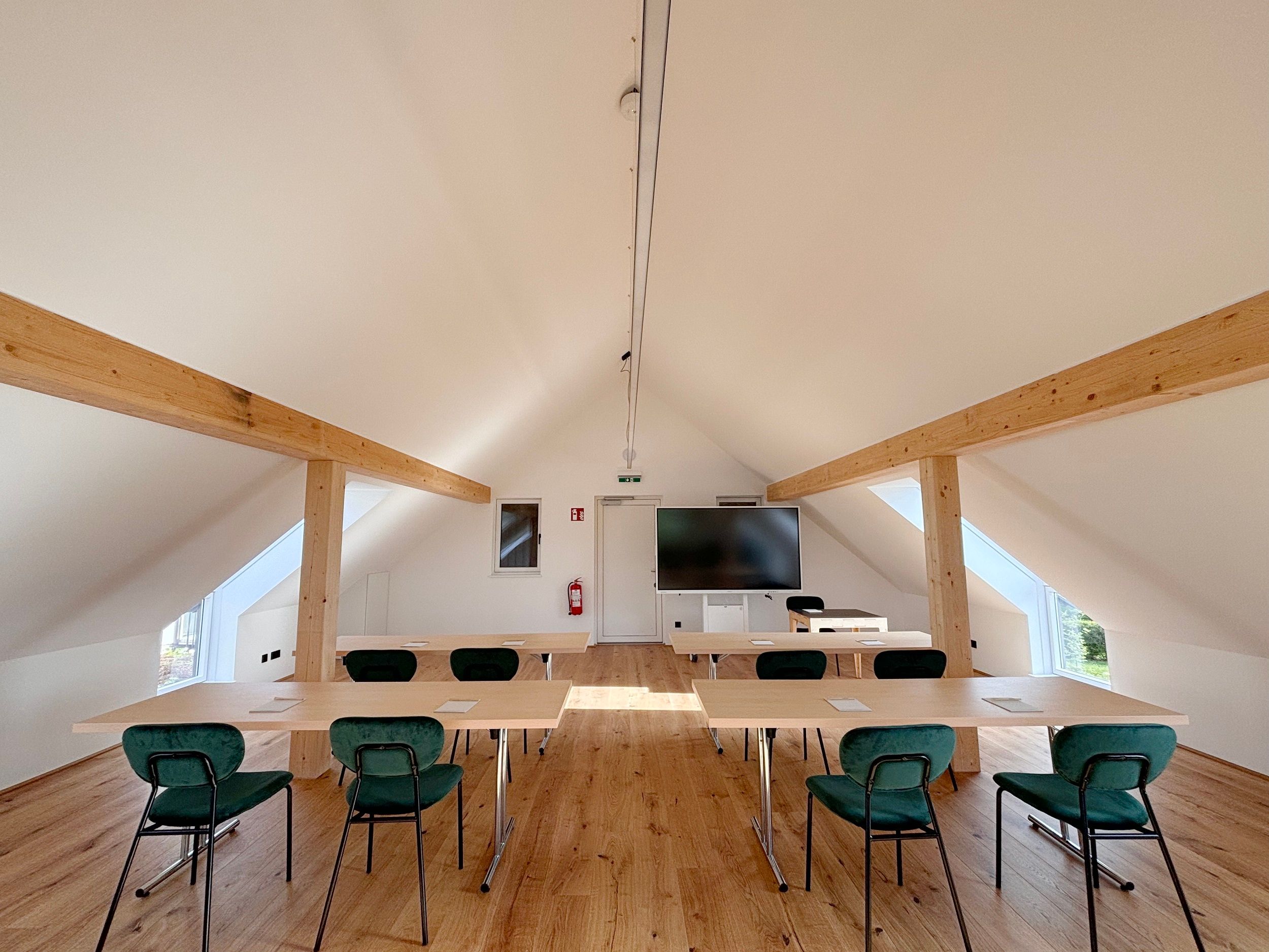 Modern seminar room with wooden beams, tables and chairs.