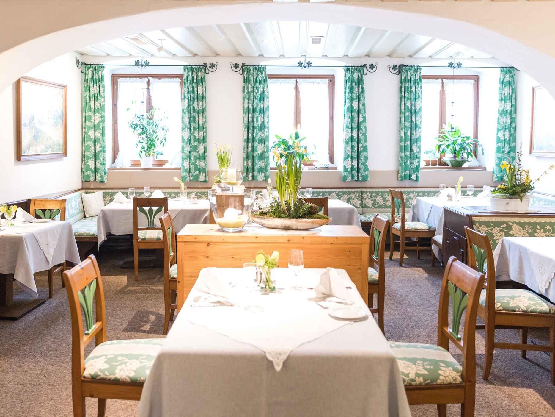 Cozy dining room with wooden furniture and green curtains.