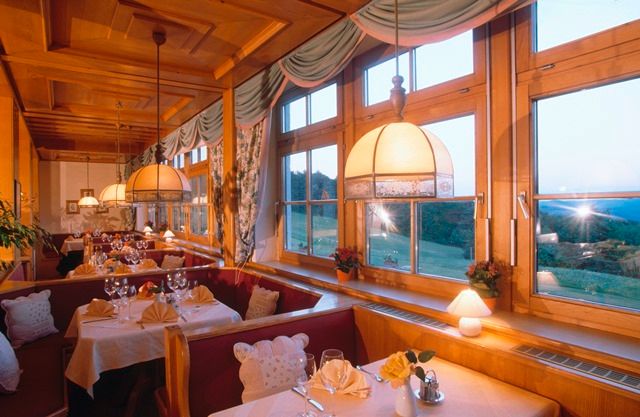 Cozy restaurant with wooden furnishings and large windows overlooking the countryside.