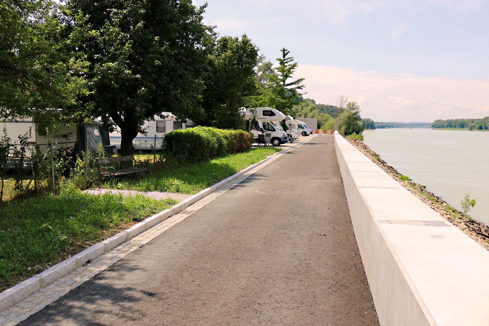 Motorhomes park along a path by the Danube.