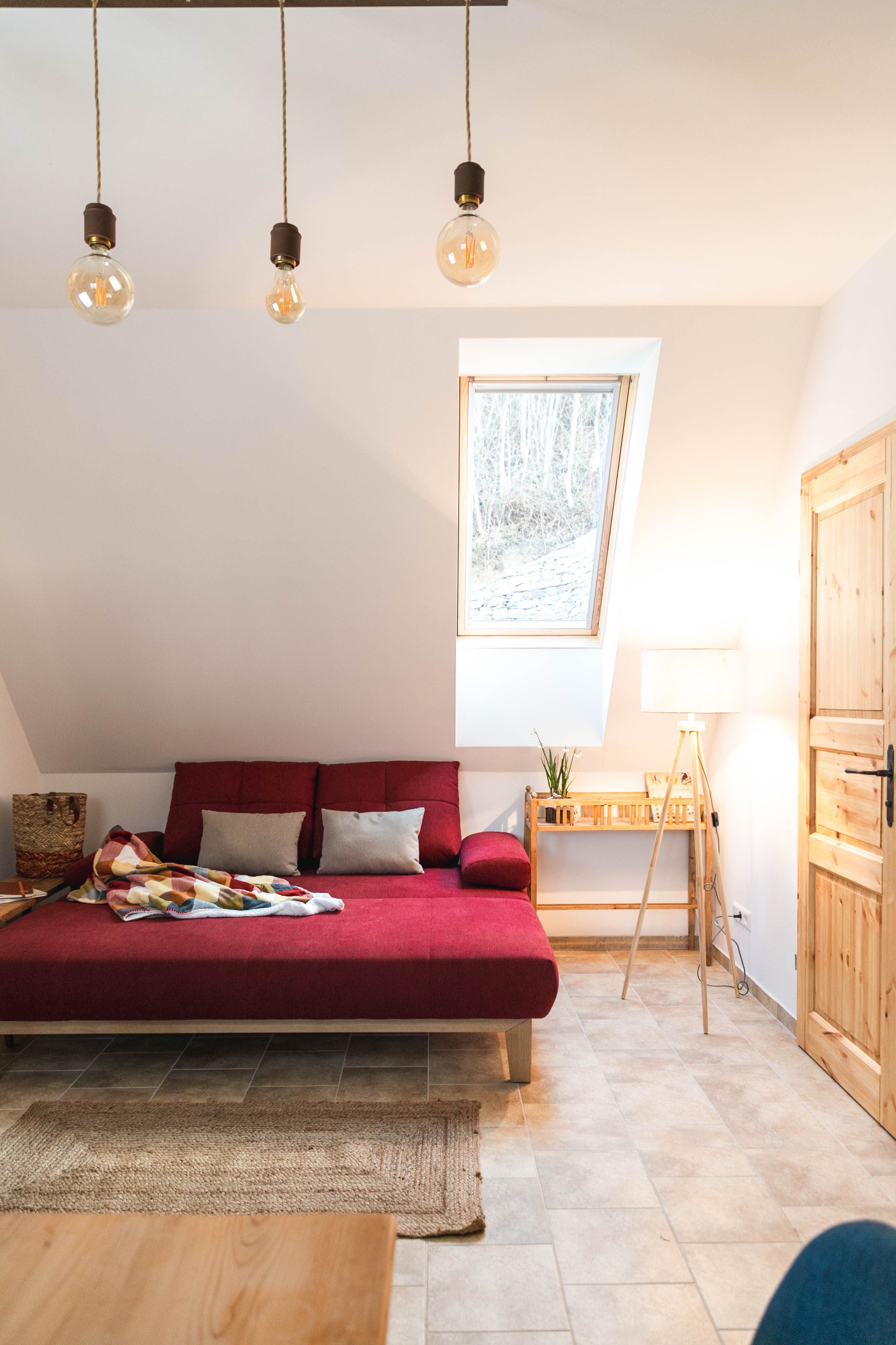 Cozy living room with red sofa, ceiling light and skylight.