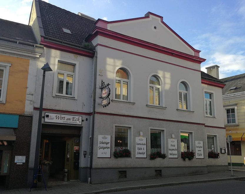 Inn with the sign 'Wirt am Eck' on a street corner.