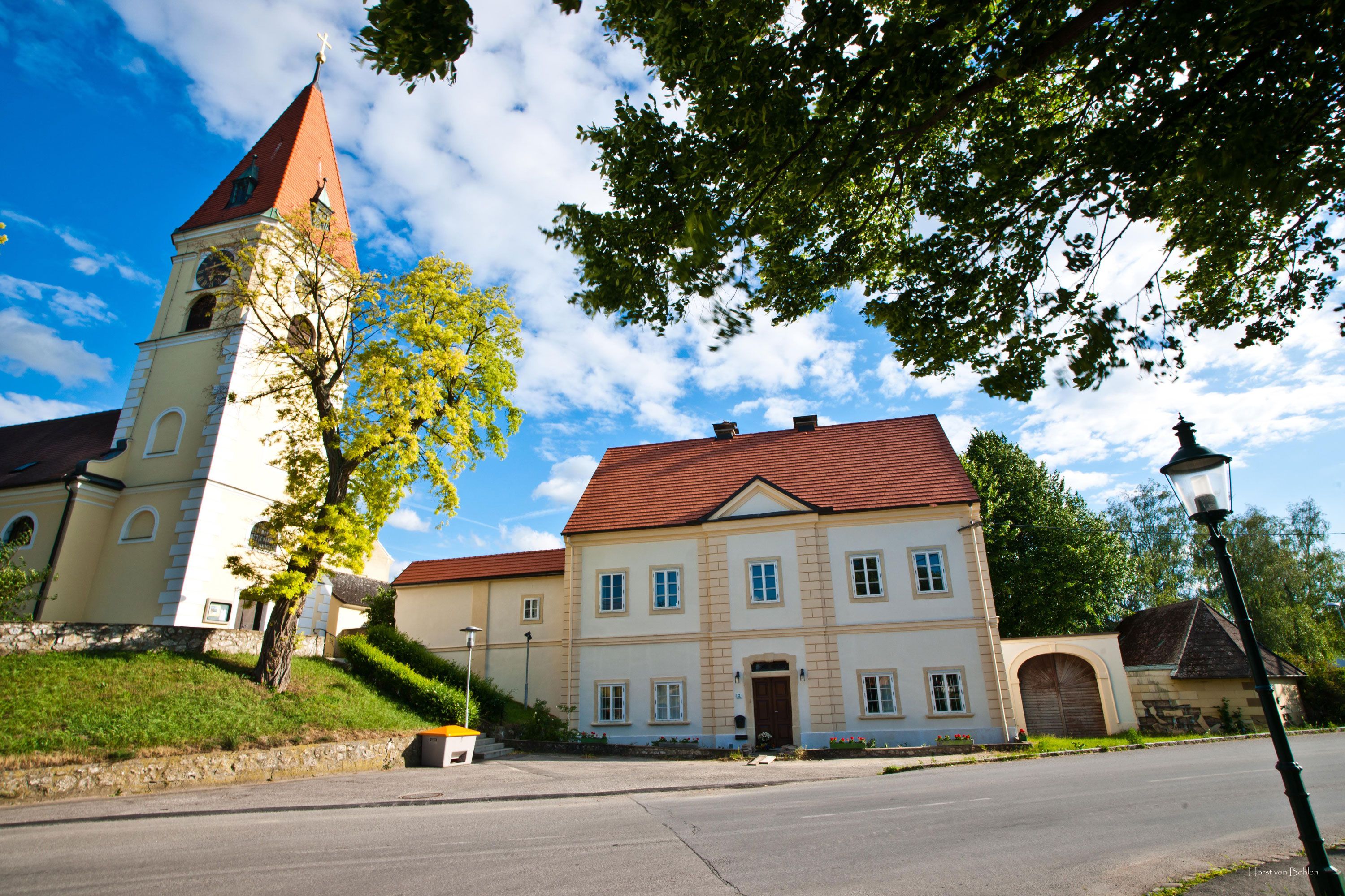 Zuschmann vicarage with church and blue sky.