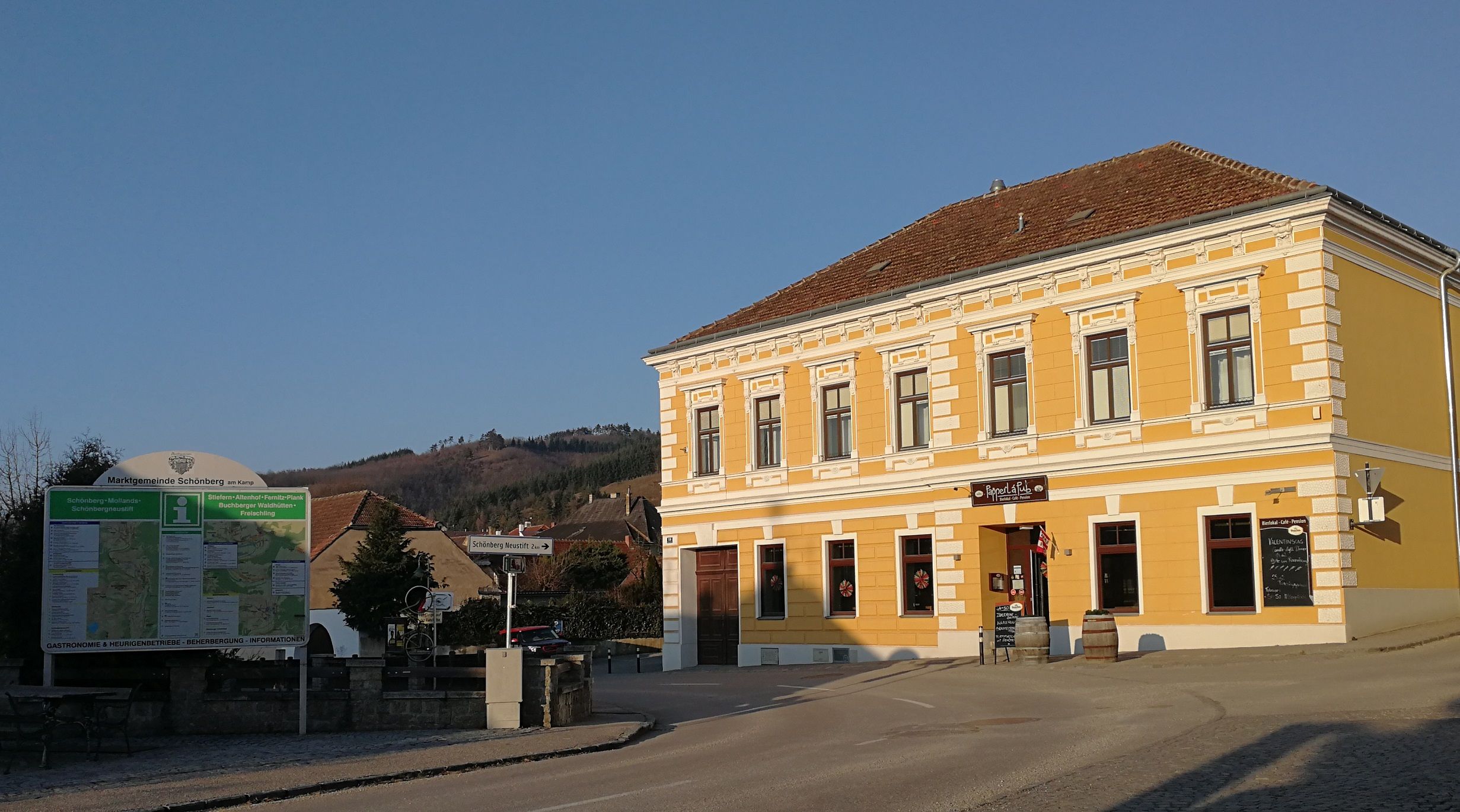 Yellow building with sign 'Papperl á Pub' in Schönberg am Kamp, Austria.