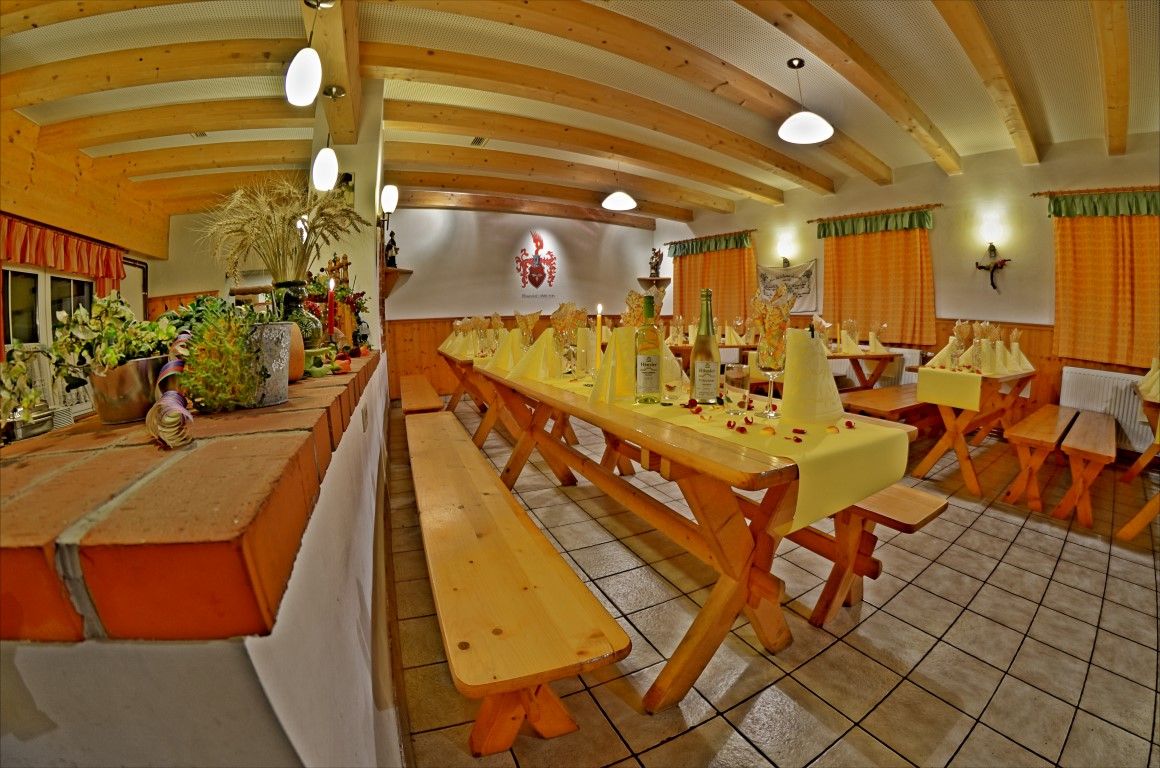 Cozy dining room with wooden tables, decorated with wine bottles and yellow napkins.