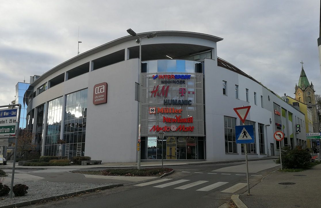 CCA Amstetten shopping center with various store logos on the façade.