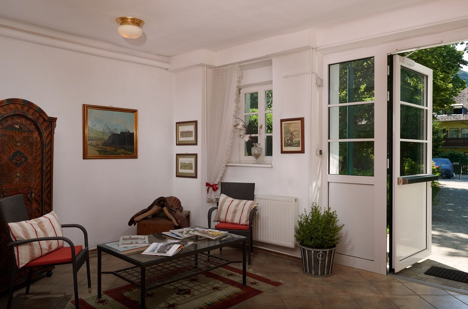 Cozy entrance area with armchairs, table and country-style decorations.