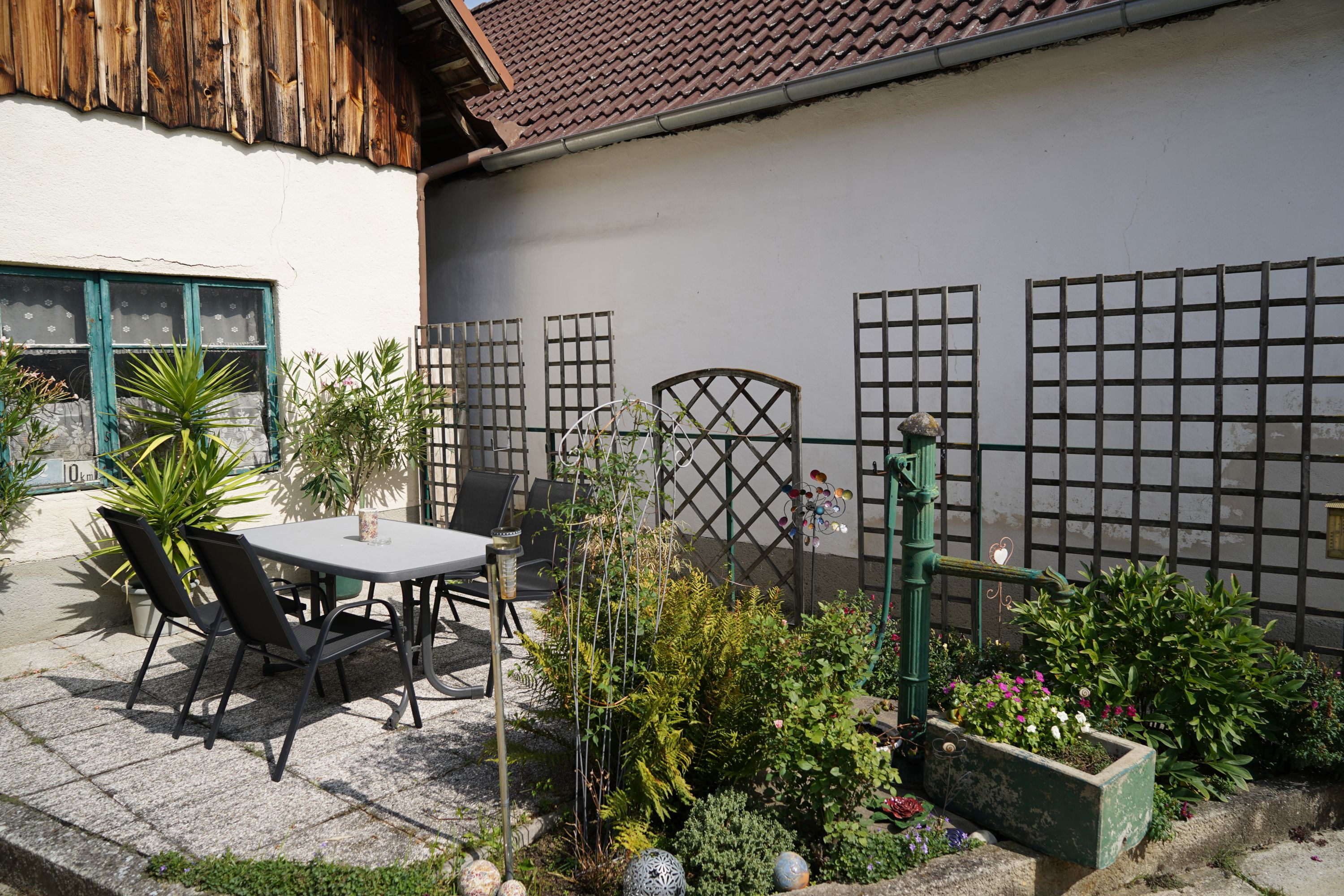 A cozy courtyard with table, chairs and plants.