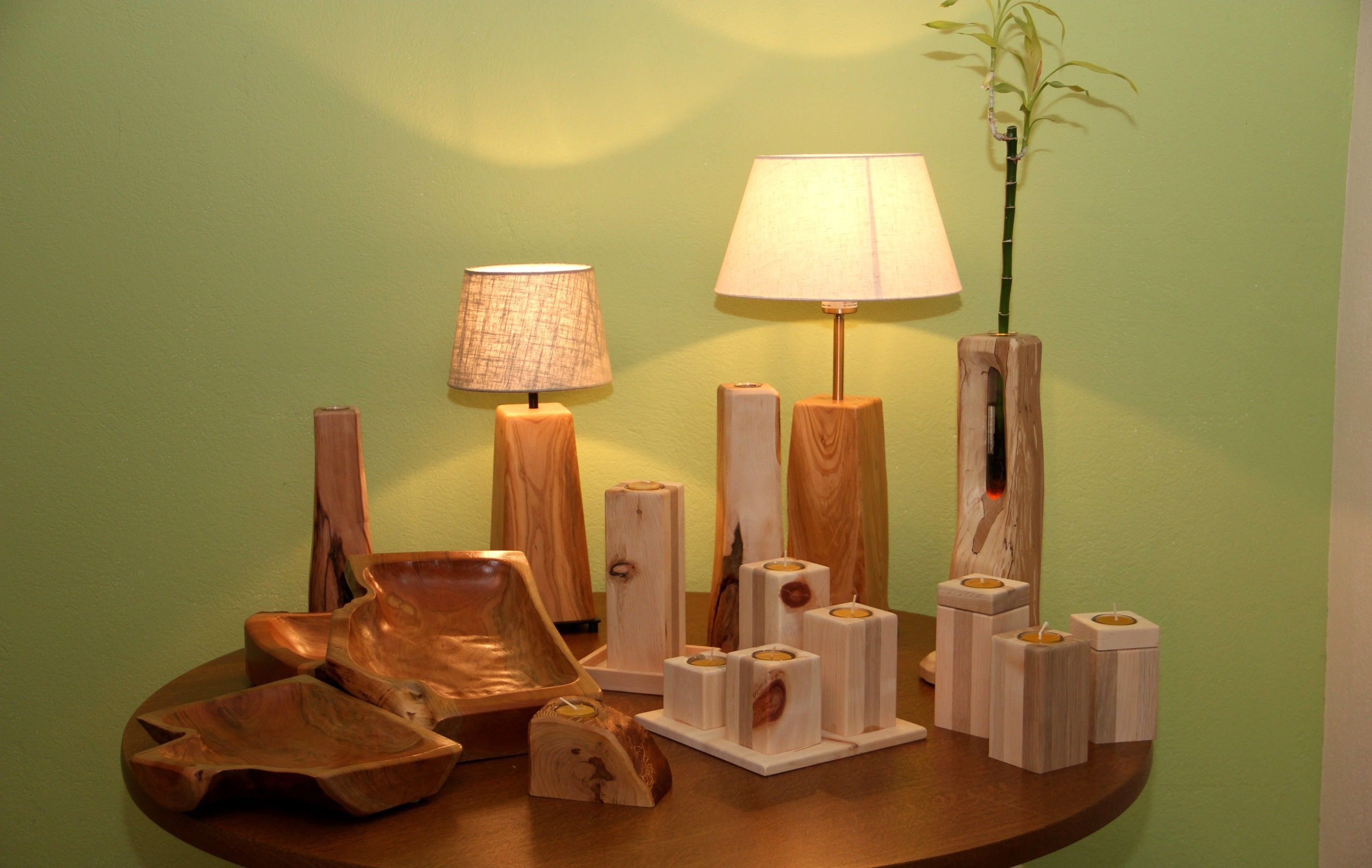 Wooden handicrafts with lamps and candlesticks on a table.