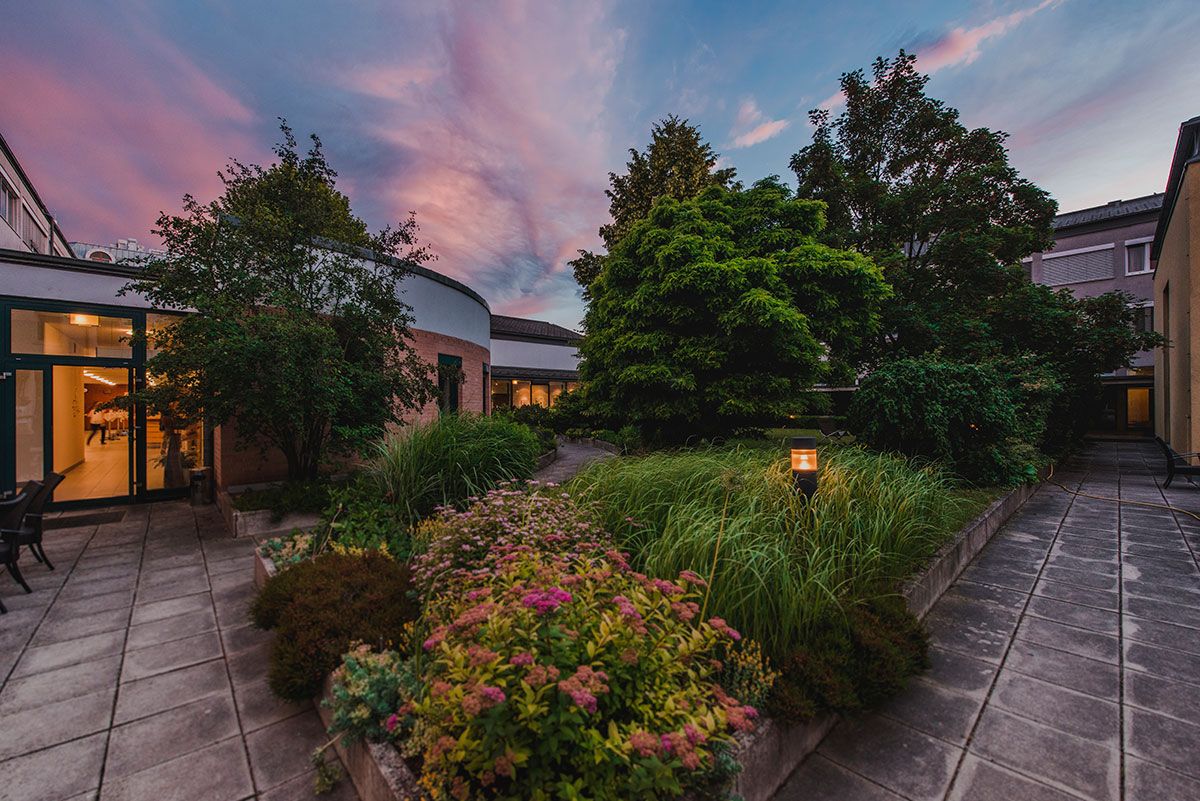 Inner courtyard of the Bildungshaus St. Hippolyt with garden and evening sky.