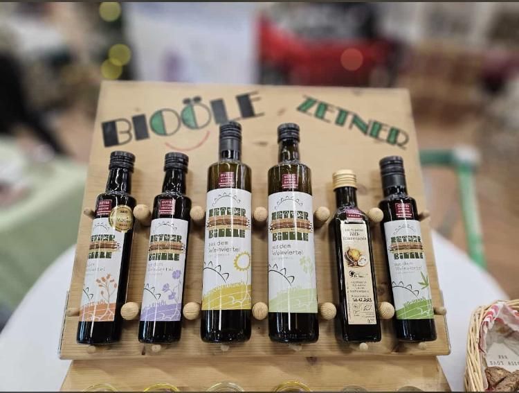 Five bottles of organic oil on a wooden stand with the inscription 'Bioöle Zeiner'.