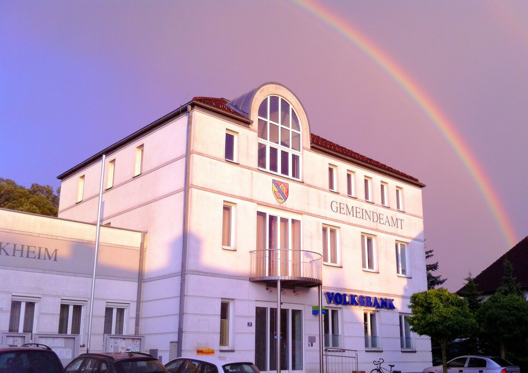Ernsthofen municipal office building with rainbow in the background.