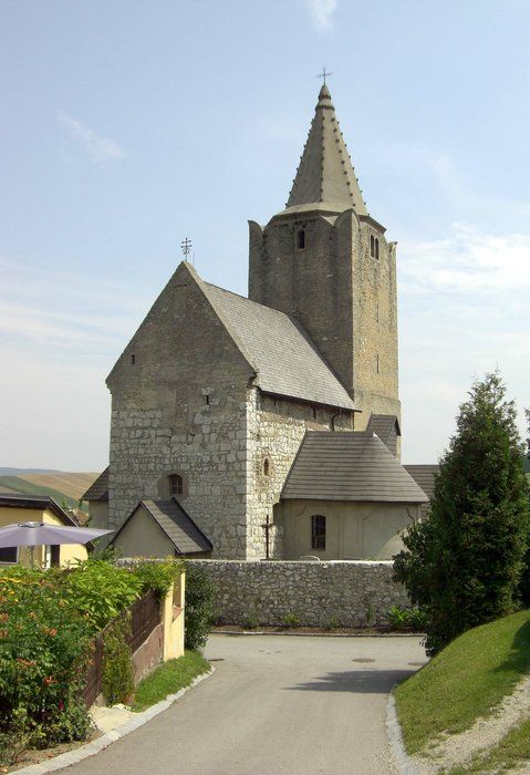 Historic fortified church with stone tower and pointed roof.