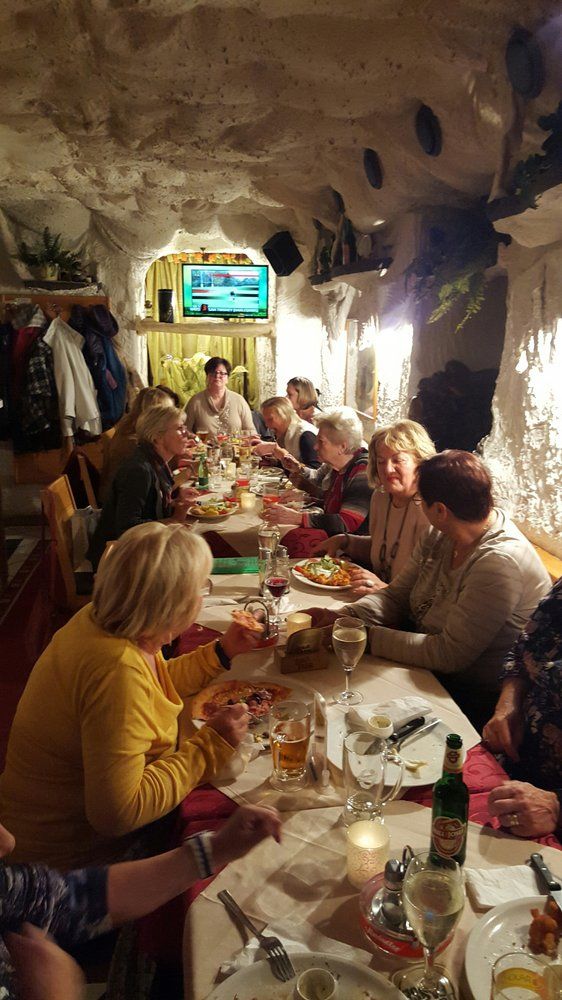 Group of people eating in a cozy pizzeria.