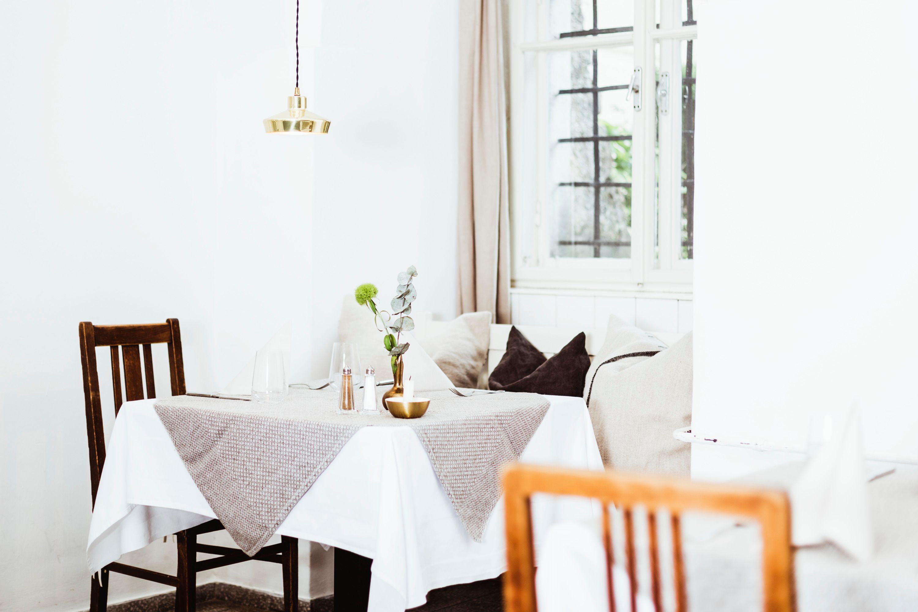 Comfortably furnished restaurant with wooden furniture and table decorations.