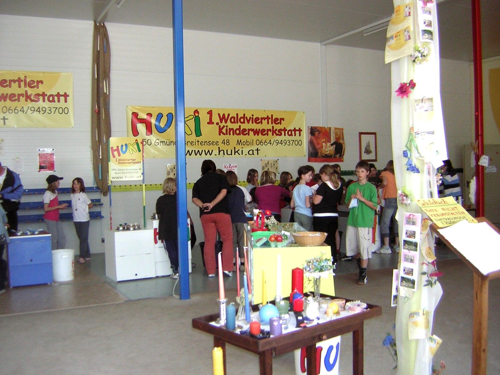 Interior view of a children's workshop with people and craft materials.
